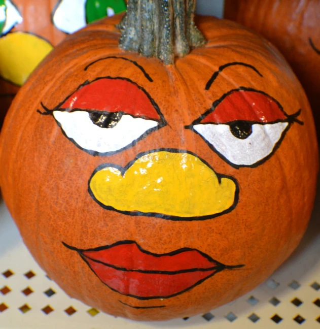 two pumpkins with painted faces and nose markings on them
