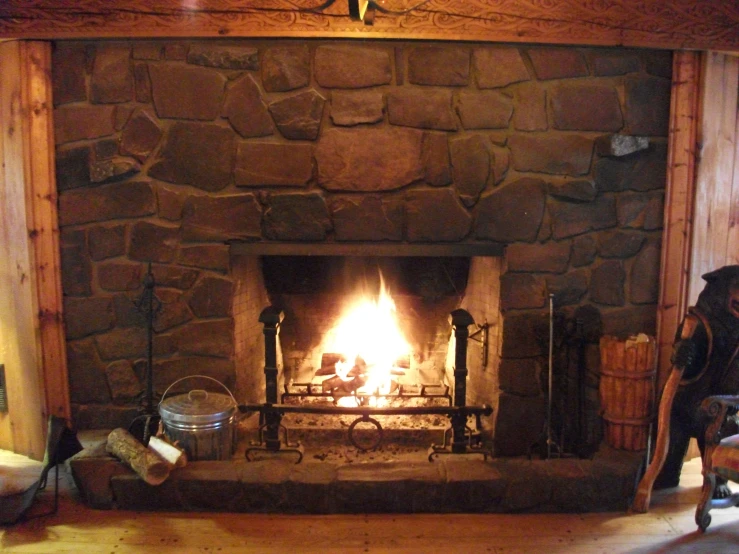 a rustic fireplace with logs and burning logs