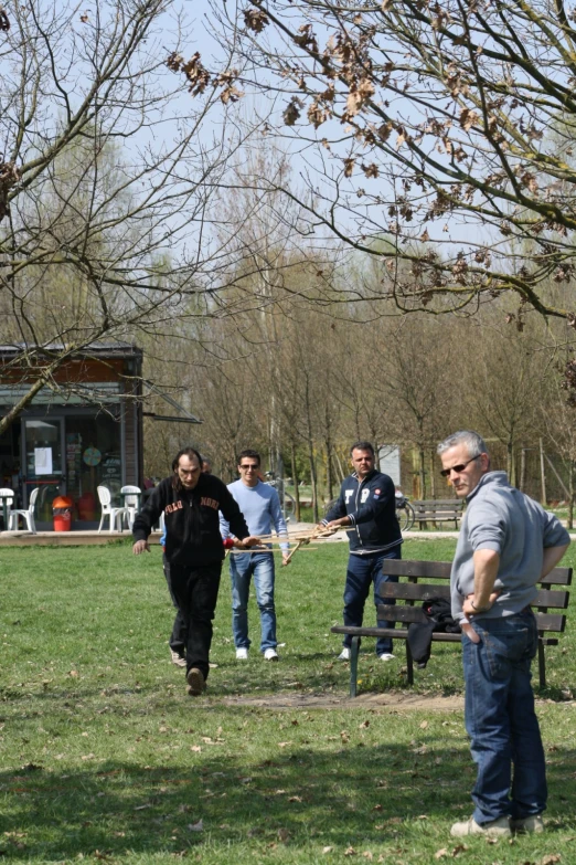 a group of people on the grass playing with frisbees