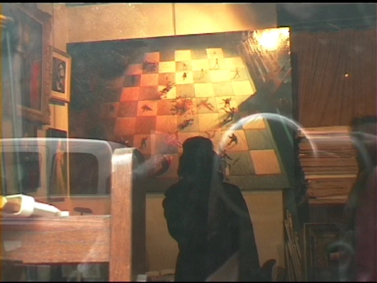 a woman leaning against a door in a shop with shelves of blankets