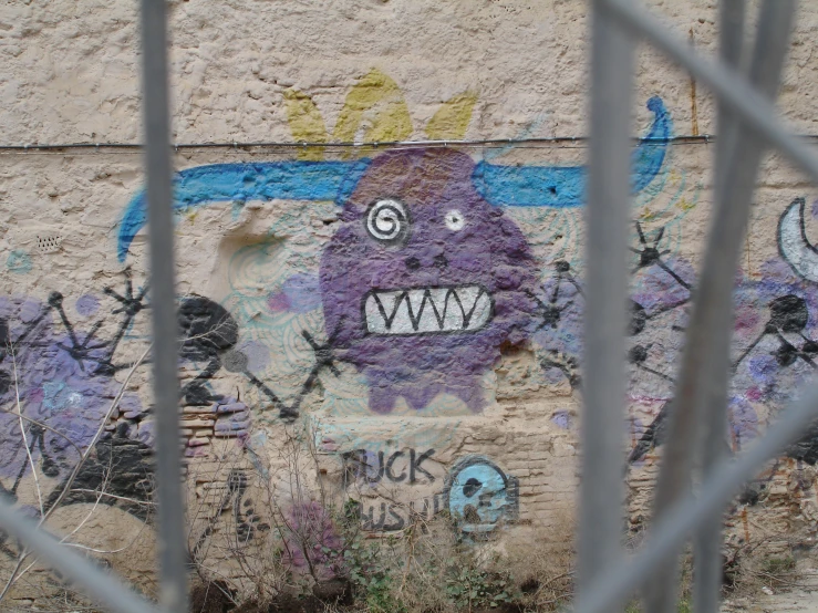graffiti on the side of a wall that has been fenced off
