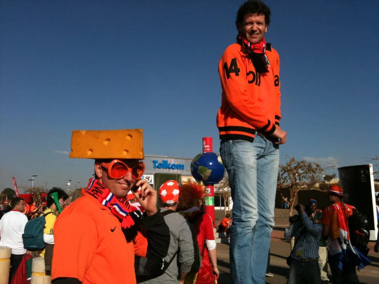 a man on the phone at an orange day in a town