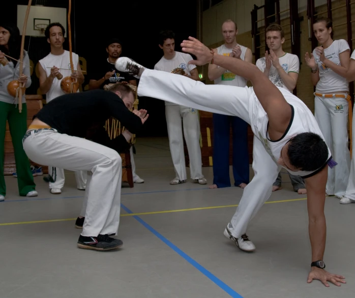 two men performing a hand stand in front of an audience