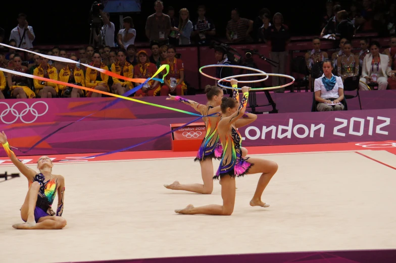 two women in colorful dress perform with multi - colored ringleaders