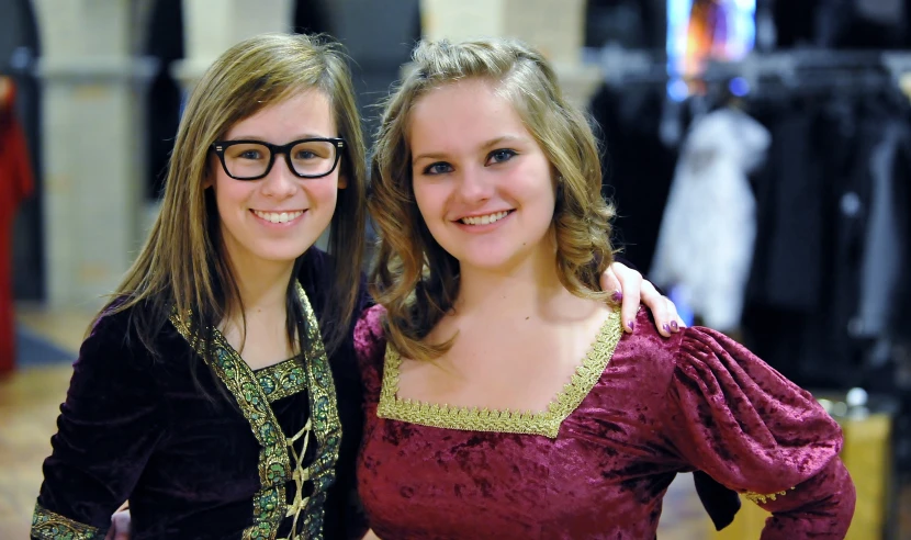 two women in dresses and eyeglasses standing next to each other