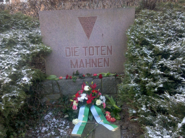 a grave with a colorful ribbon and flowers on it