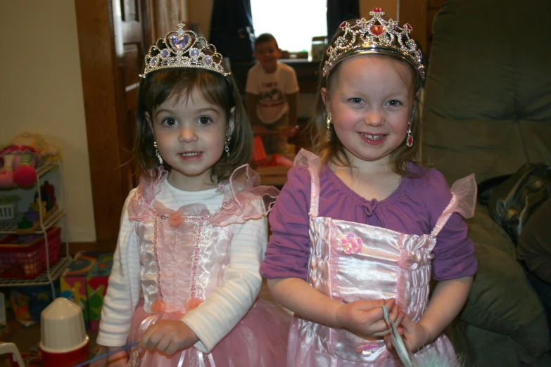 two girls dressed in princess themed clothing posing for the camera