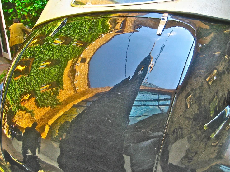 an old vehicle that has a tree reflection in the window