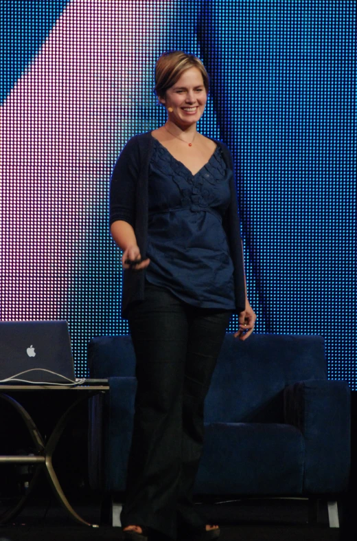 a woman standing on stage during a conference