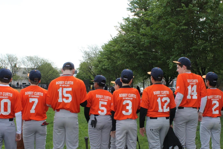 a baseball team with numbers printed on their orange uniforms