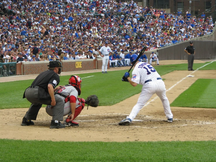 a batter, catcher and umpire during a baseball game with the packed audience