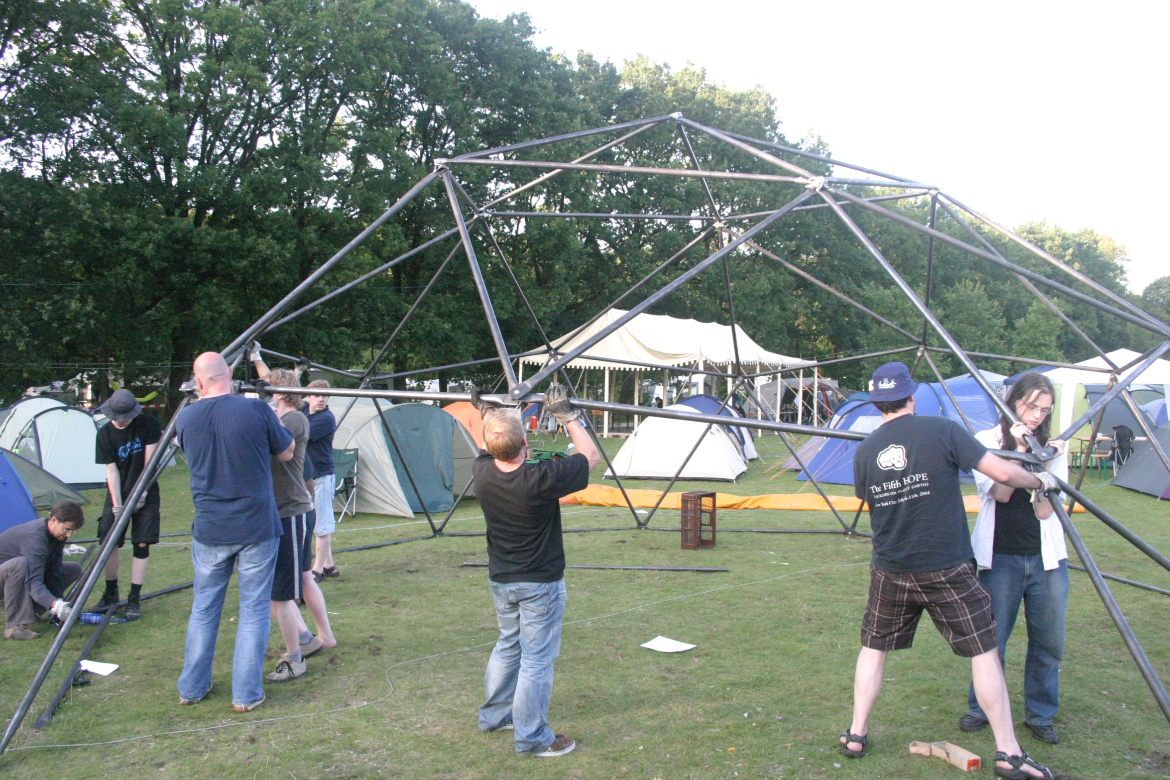 a group of men with equipment standing around a tent