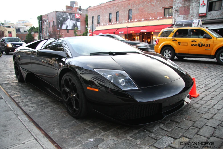 a parked black sports car in the middle of the street