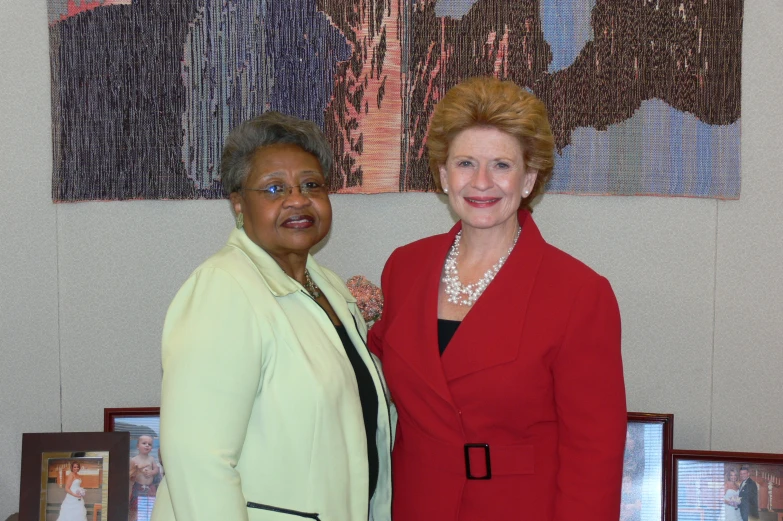 two women stand next to each other near pictures