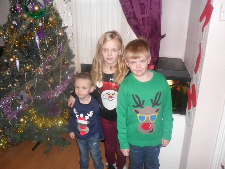 a family standing together in front of christmas trees