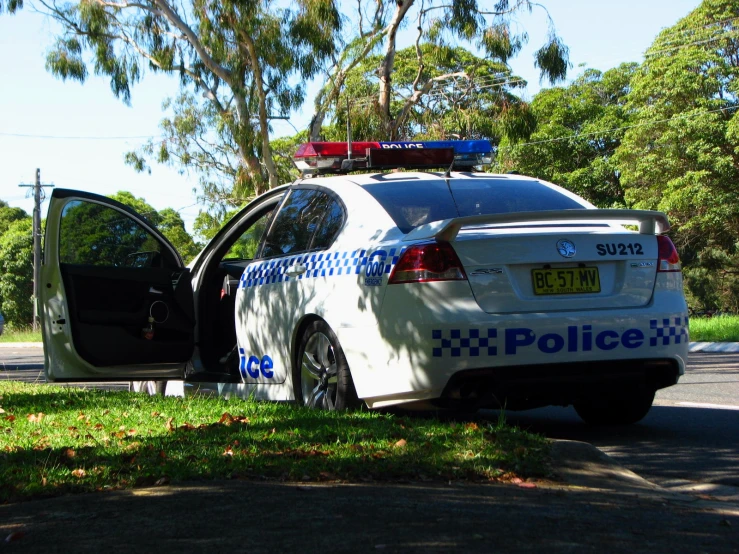 an automobile with its door open is parked on the side of a road