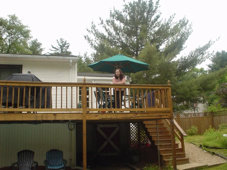 a woman standing on top of a deck holding an umbrella