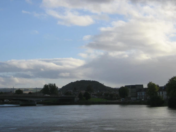 the water is dark blue and calm, with clouds in the sky