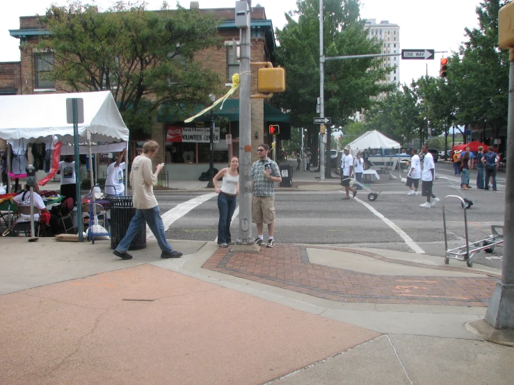 a busy street with people walking around and vendors selling things