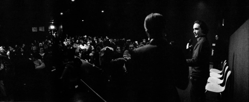 man in black jacket staring away in crowd at concert