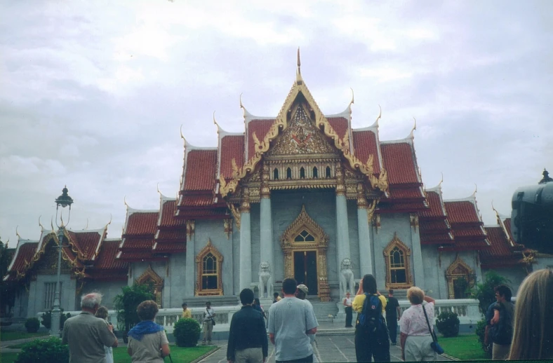 people are standing outside a building with many details