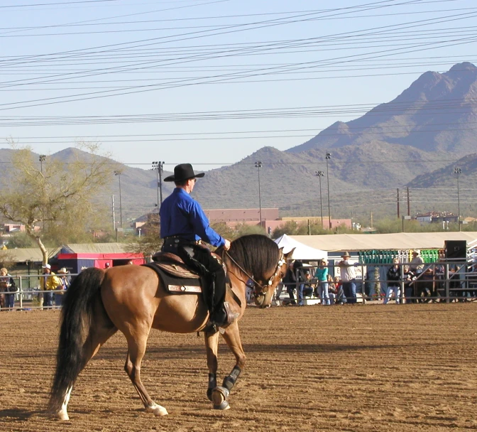 the person is riding his horse in the saddle