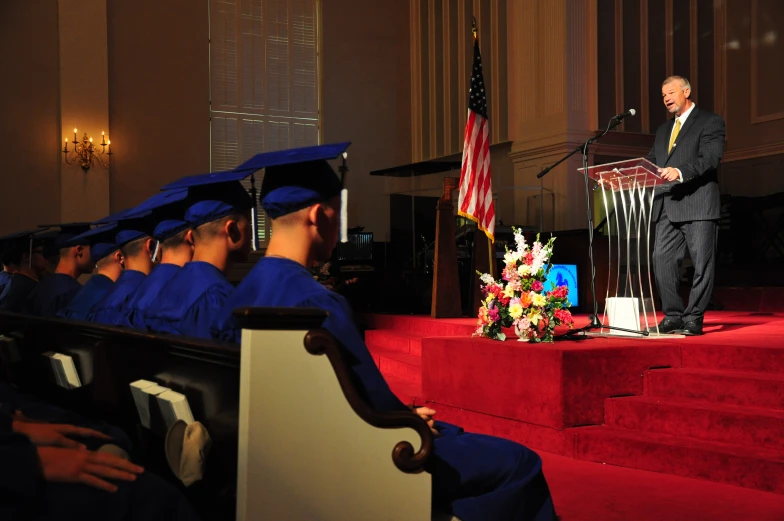 the man in the suit is standing at a podium