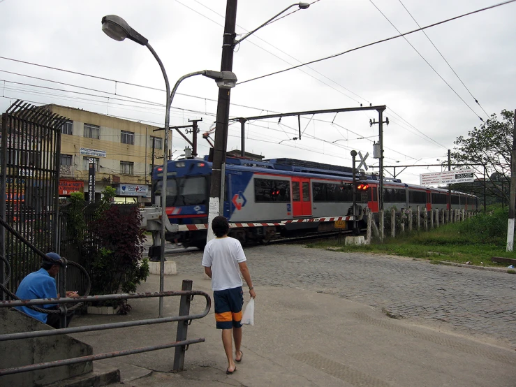 there are people walking towards a train going down the track