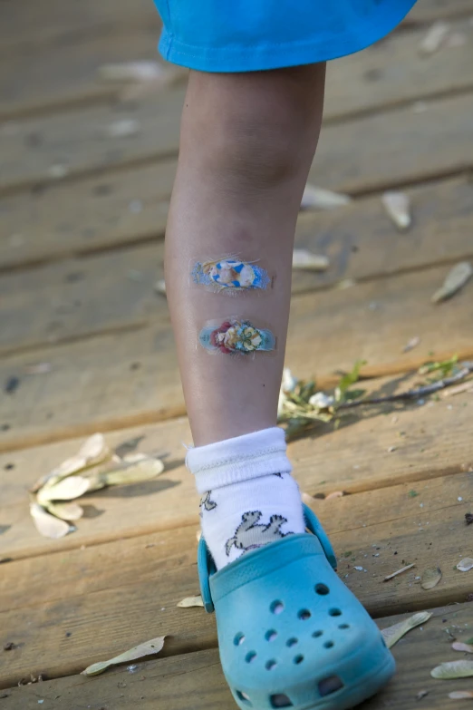 small foot with a blue pair of shoes and flowered socks