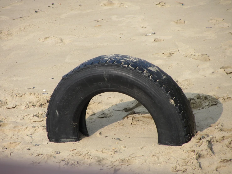 a black tire laying in the sand