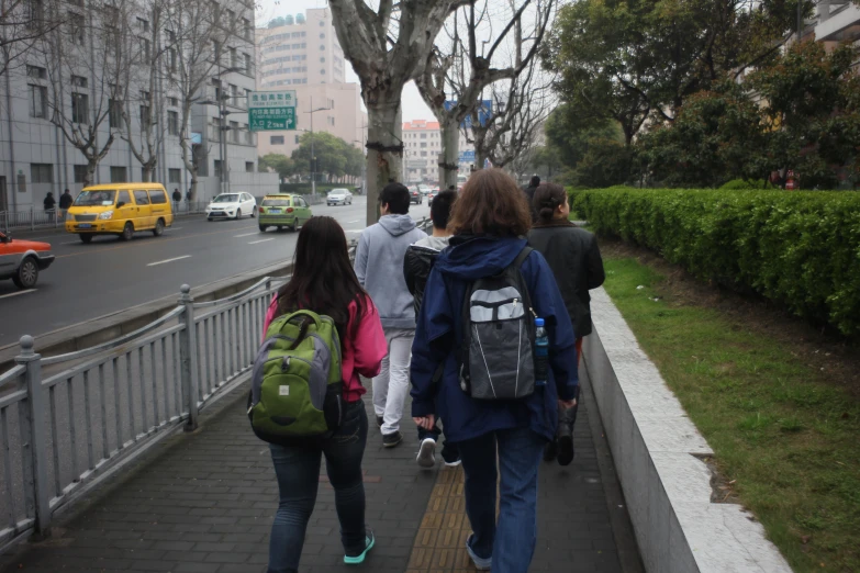 people walking down a sidewalk in a city