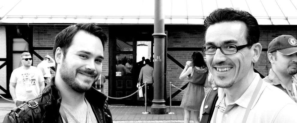 black and white image of two men outside a building