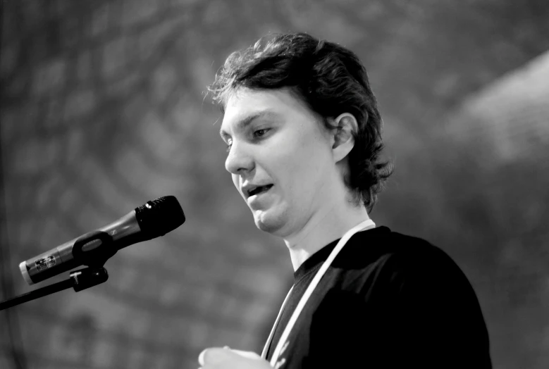black and white pograph of young woman with microphone