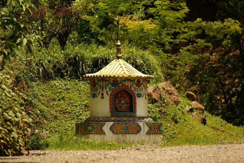 a statue on a road by a forest