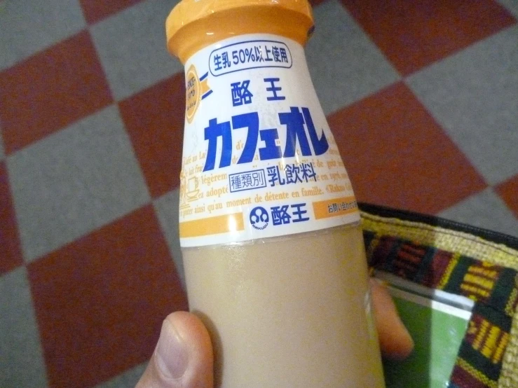 a bottle of mustard sitting in a hand
