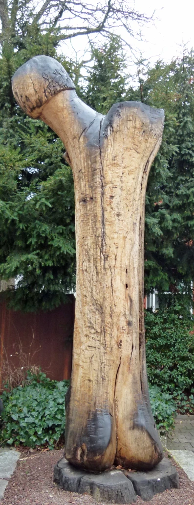 the large wood carving is shaped as a human