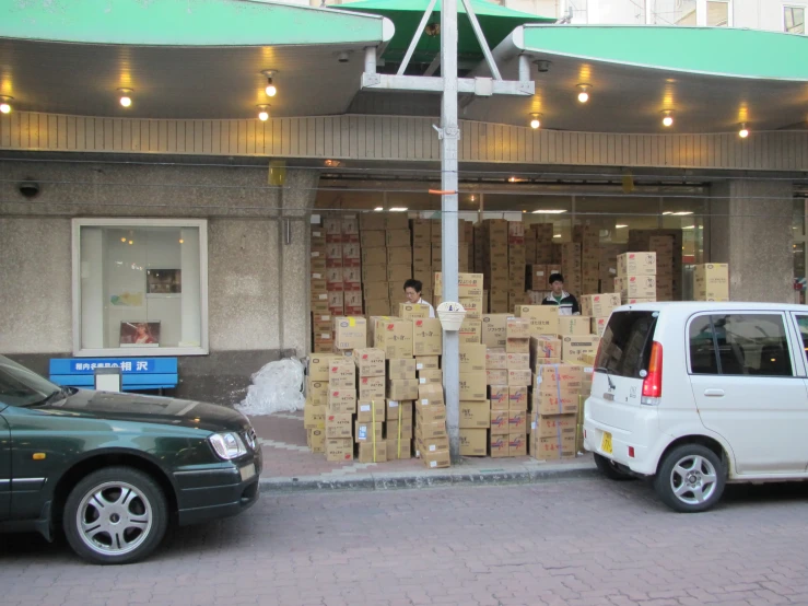 people are standing near cardboard boxes in front of a building