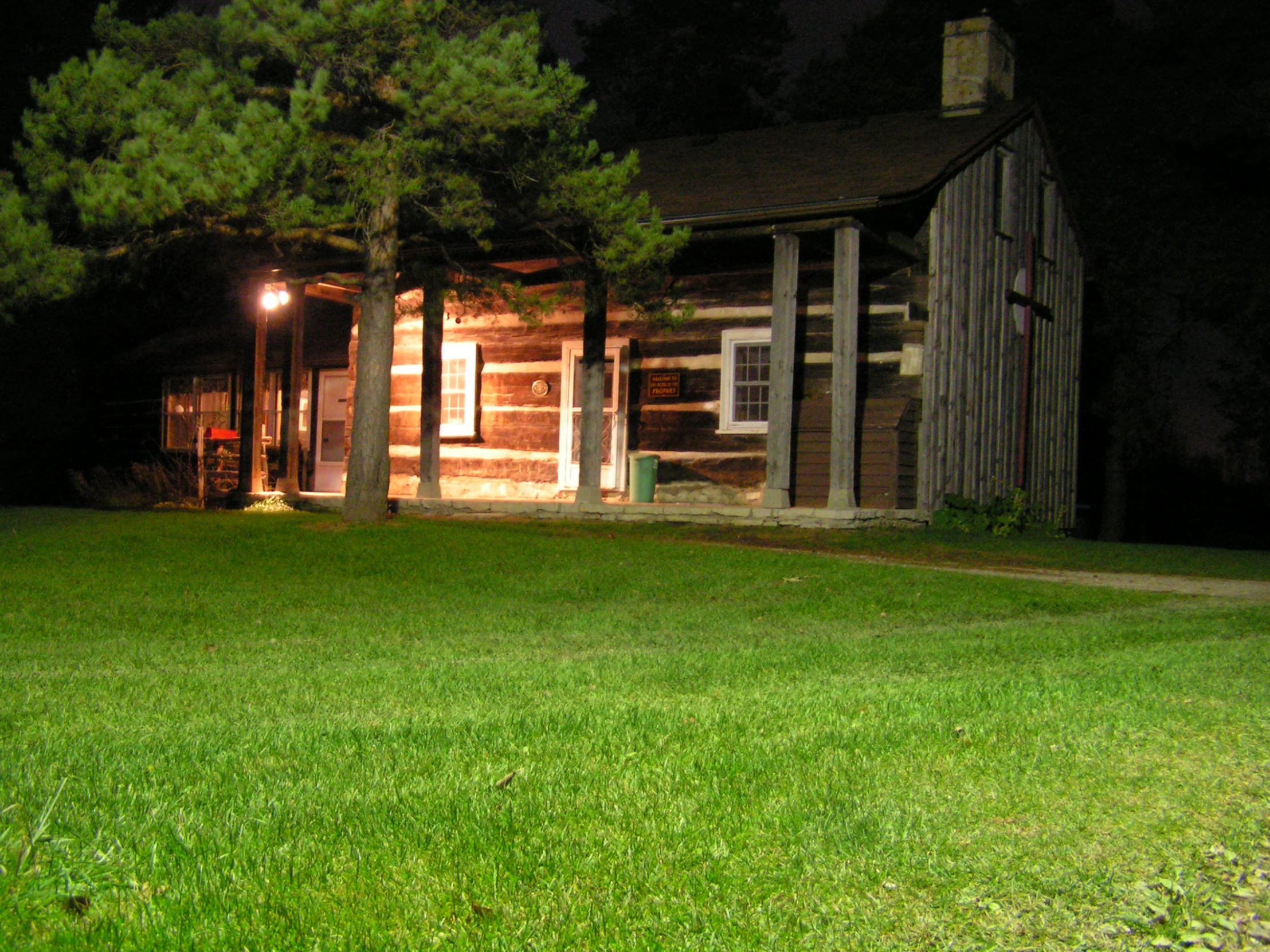 a log house on grass in the evening