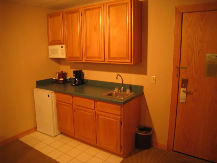 a kitchen area with a sink, cupboards and cabinets