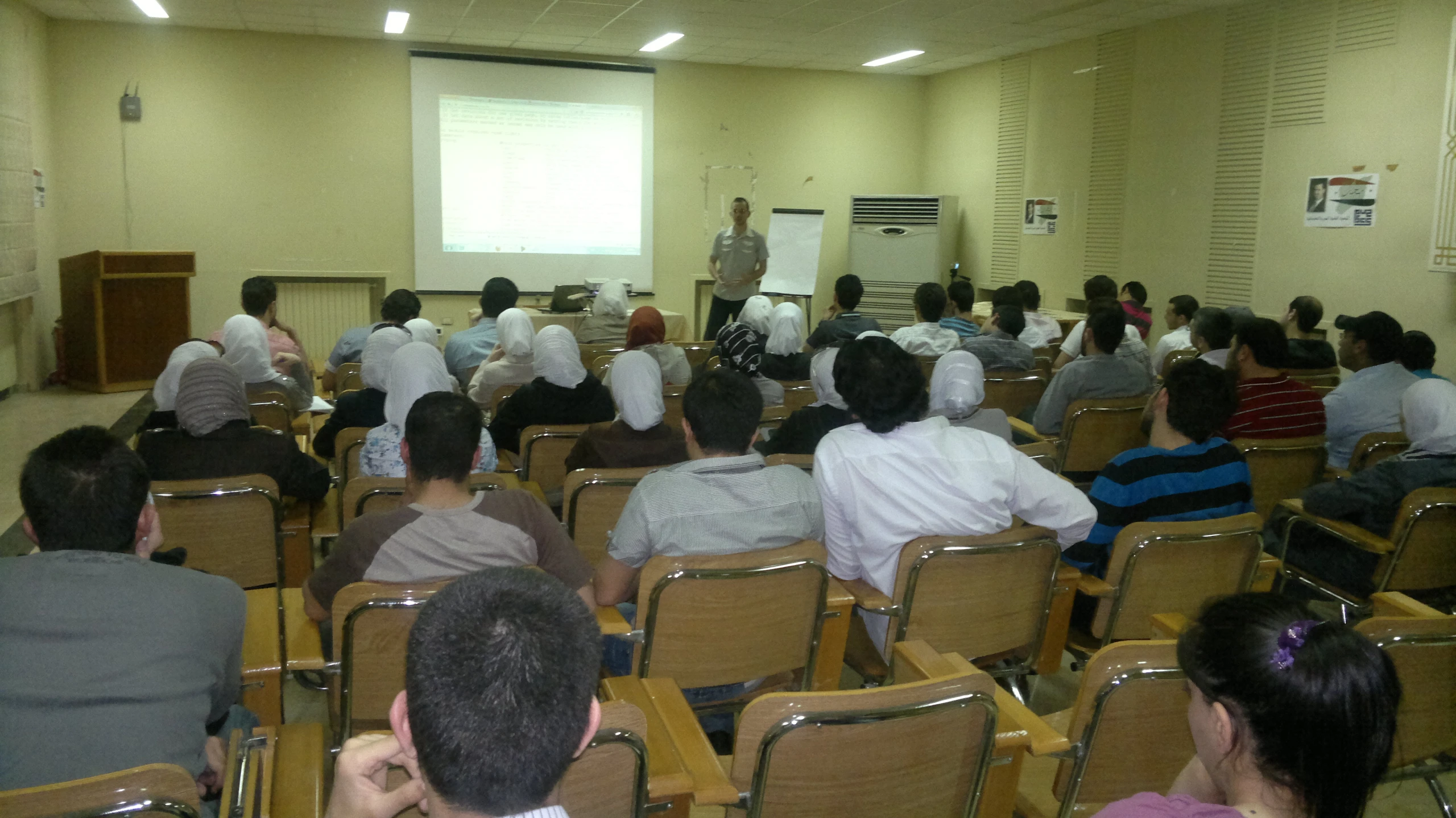 a class room with several men and women facing the front of the room