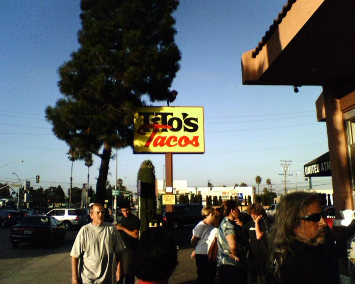 a group of people walk down the sidewalk