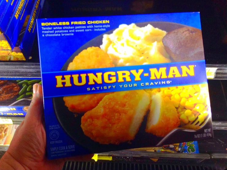the person is holding the box of hungry man