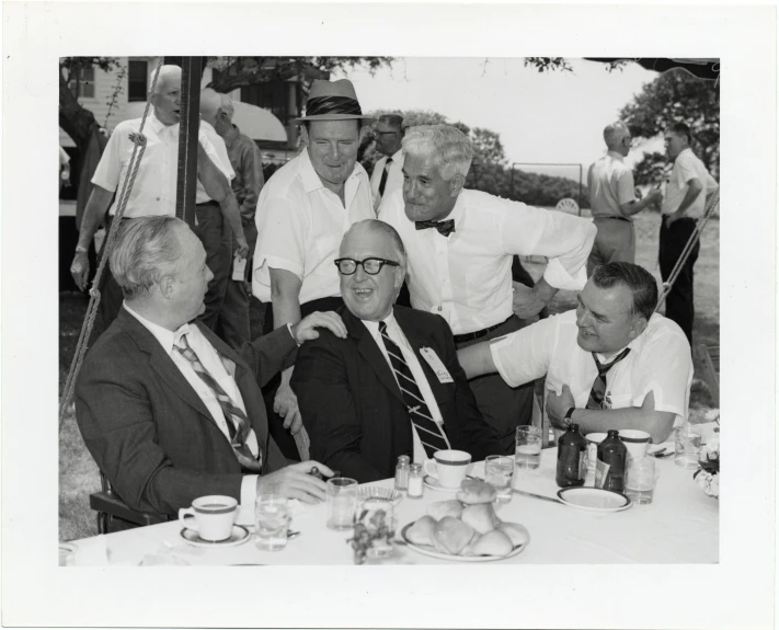 vintage black and white po of a group of men at a dinner