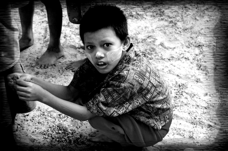 a young child that is sitting on the ground with soing in his hand