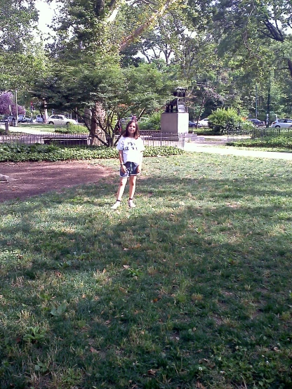 a little girl is playing frisbee in the park