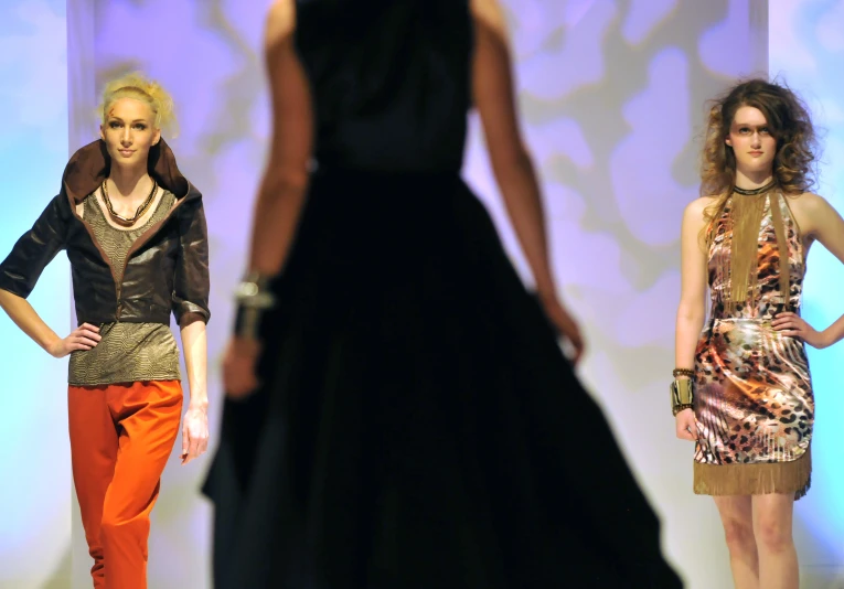 three models wearing colorful outfits and statement necklaces