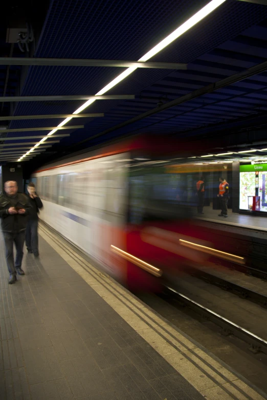 the train arrives at the platform with people on it