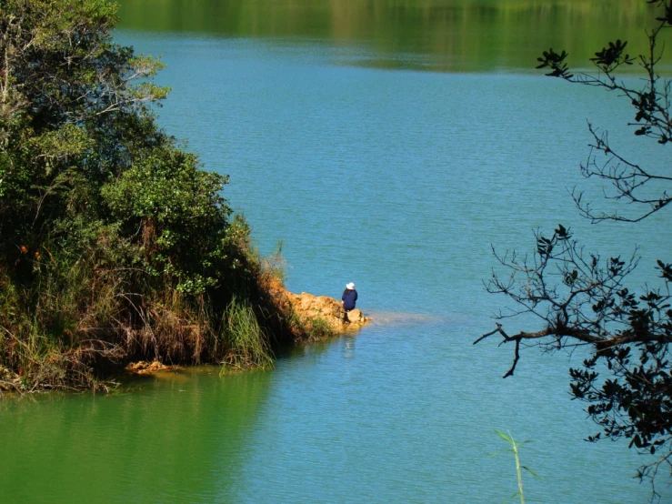 a man standing on top of a cliff above a lake