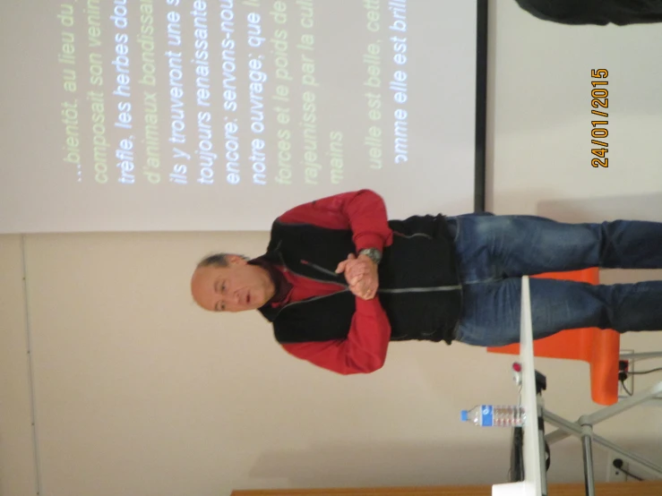 a man stands in front of a projection screen and gives a presentation