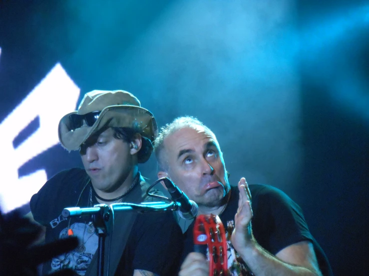 two men with hats on on a stage